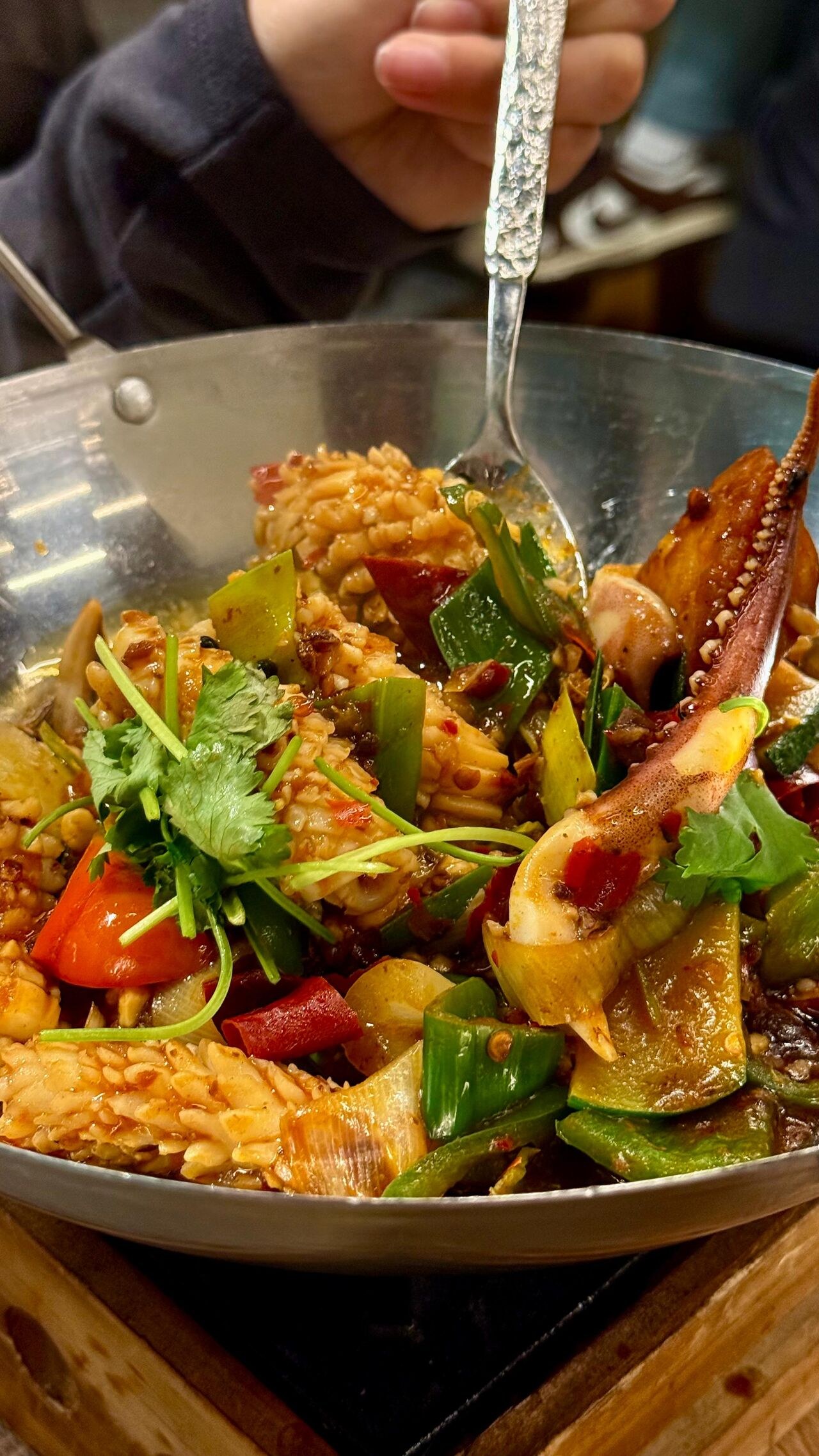 Calamari saltati con peperoni e coriandolo.