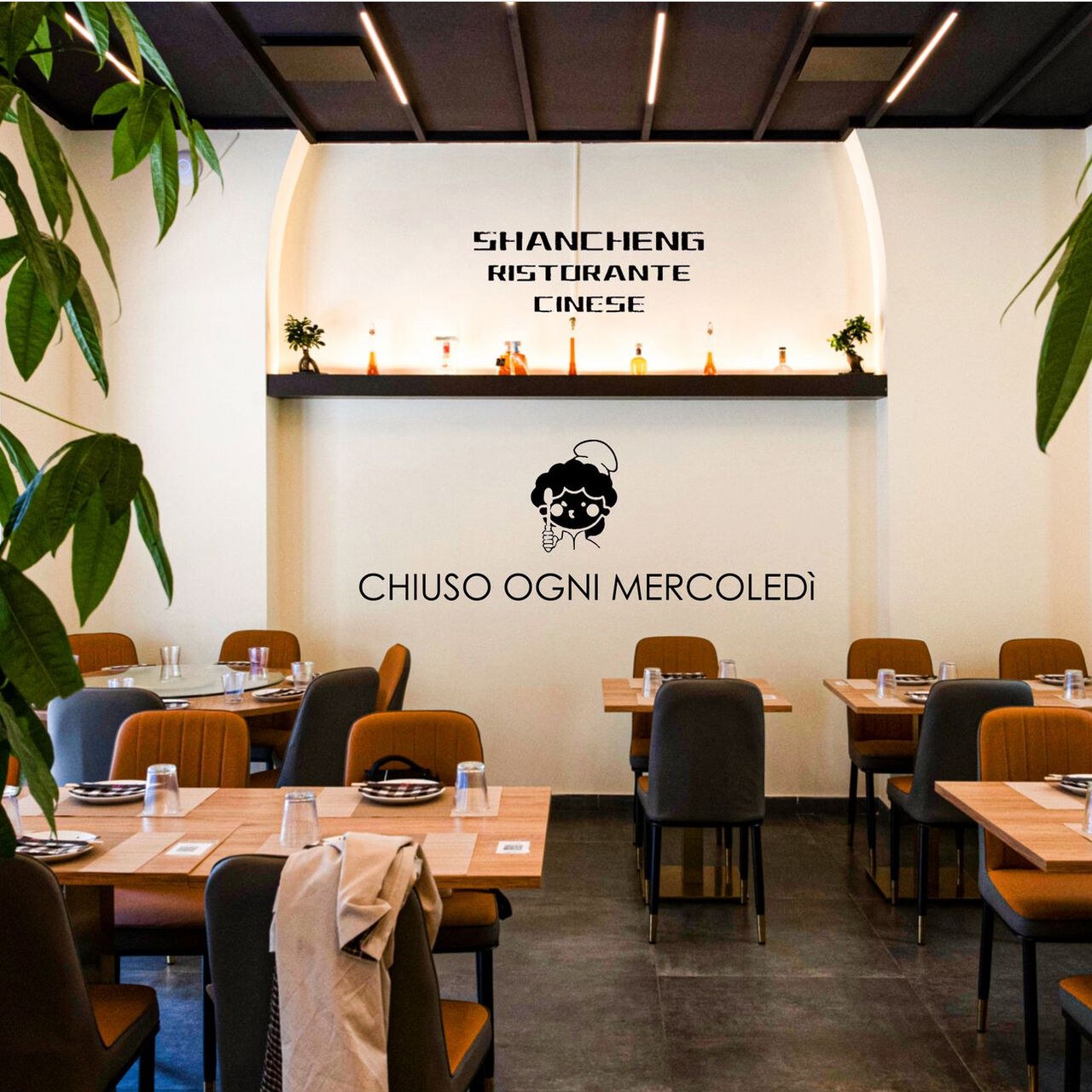 Parete della sala con la scritta Shancheng Ristorante Cinese e il marchio del locale.